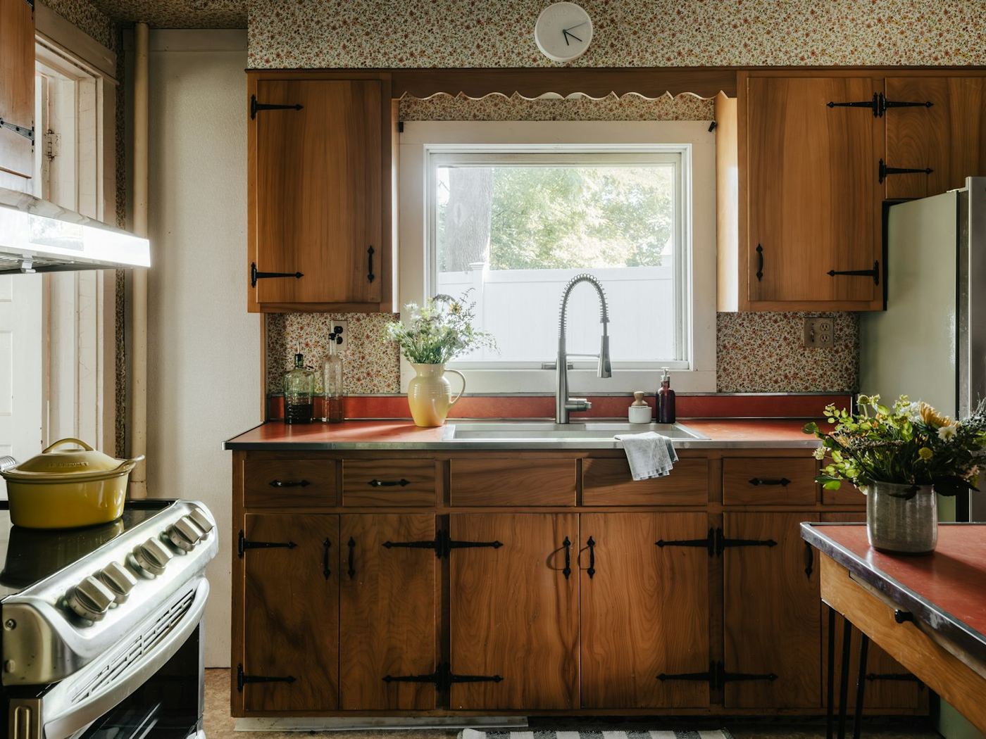 A dated timber kitchen with heavy grain doors and an old benchtop.
