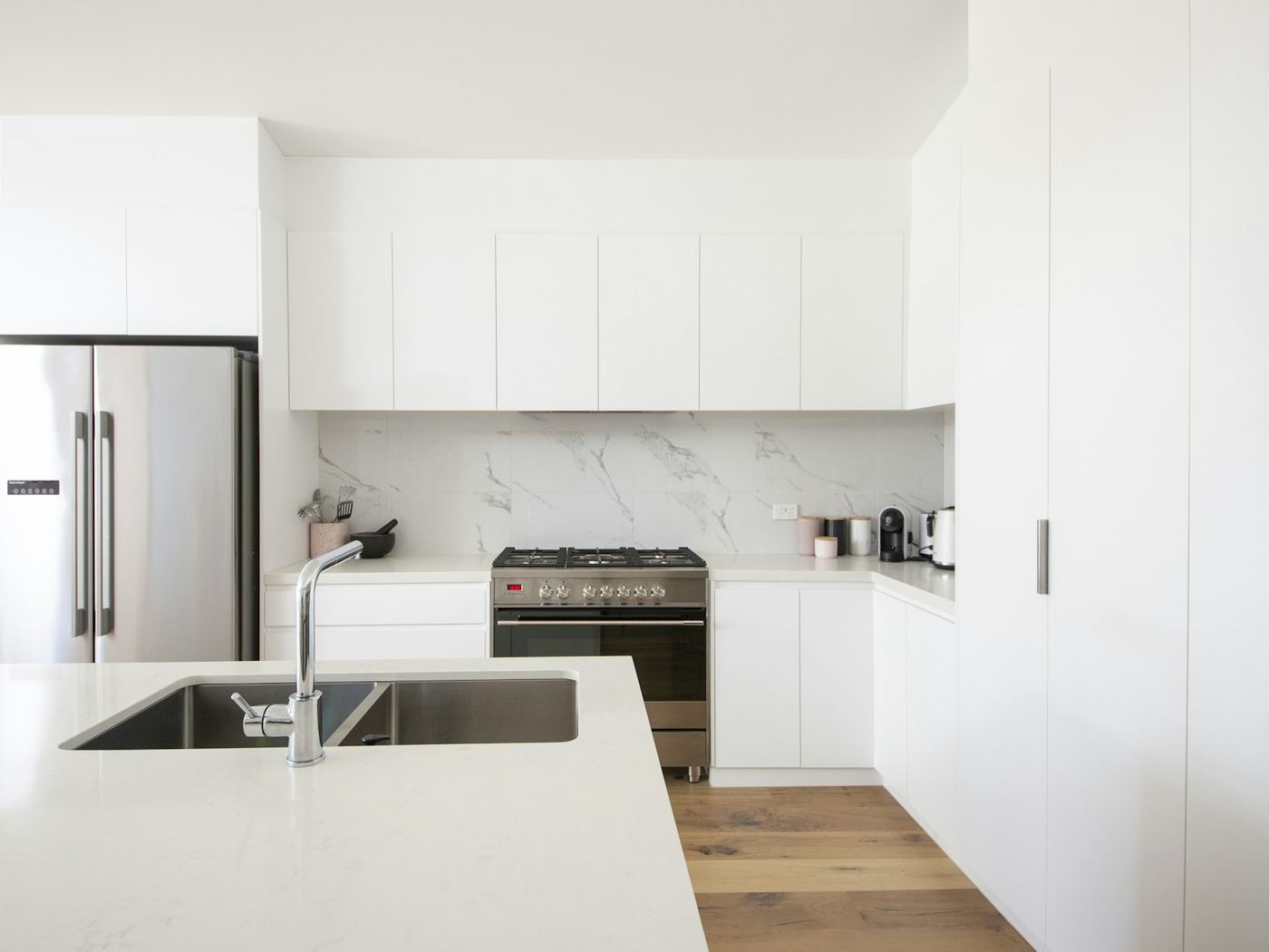 A handleless kitchen in satin white with a deep island bench.