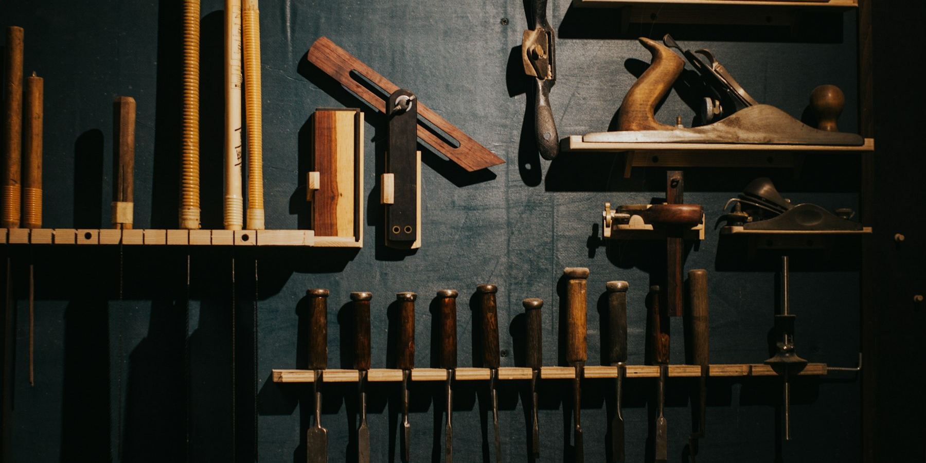 Hand tools racked in order along a workshop wall.